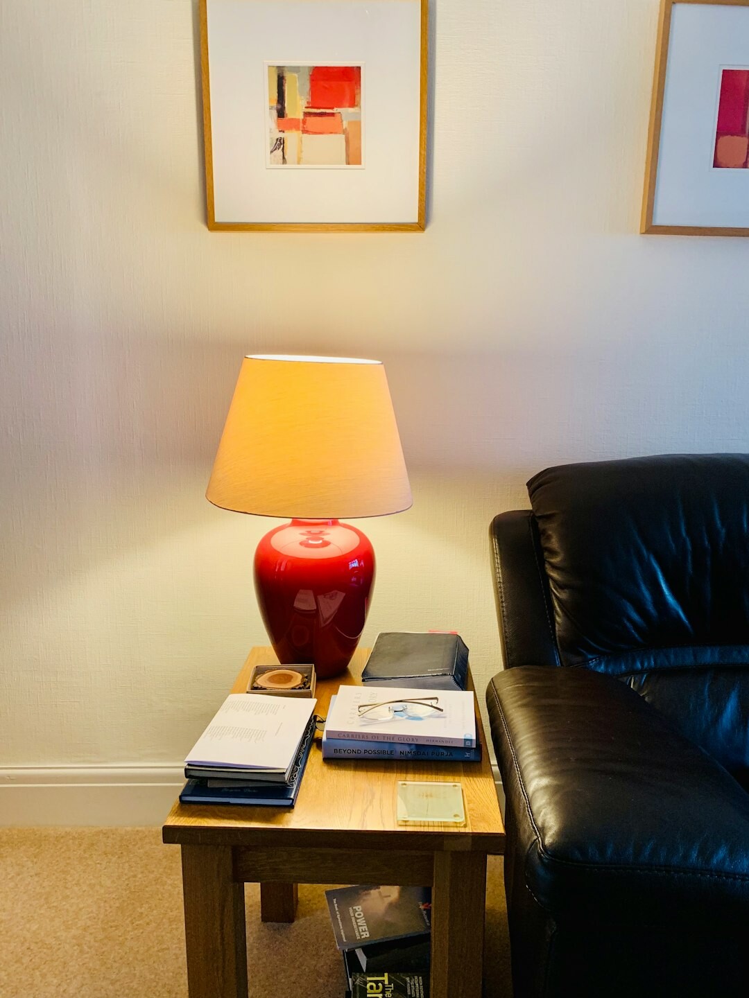 Cozy reading corner with an armchair, a lit lamp and an open book